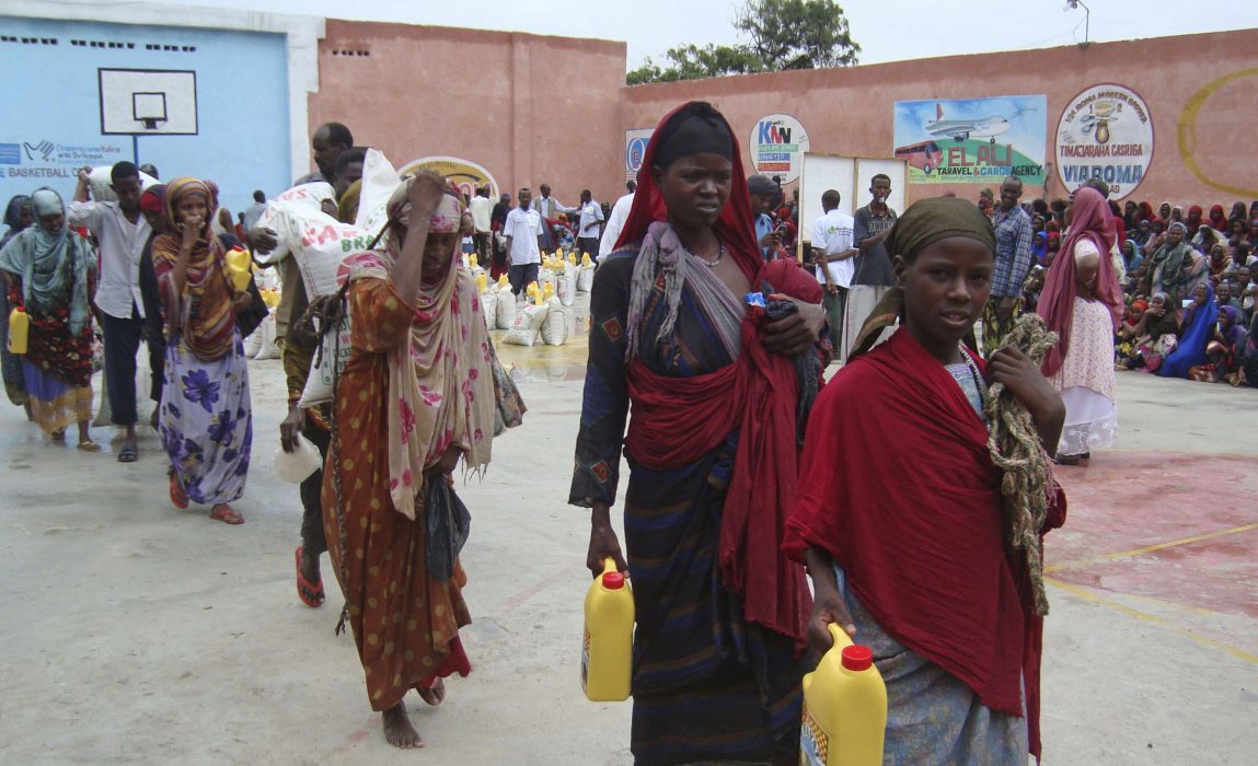 Women from southern Somali carry food after receiving aid from a Muslim organization in Mogadishu, Somalia after fleeing from southern Somalia, Sunday, July 10, 2011. Thousands of people have arrived in Mogadishu over the past two weeks seeking assistance and the number is increasing by the day, due to lack of water and food. Aid agencies are appealing for tens of millions of dollars in emergency funding to fight a drought that has created a triangle of hunger where the borders of Ethiopia, Kenya and Somalia meet. (AP Photo/Farah Abdi Warsameh) Människor som flytt från hungern och torkan i södra Somalia 2011 får hjälp av en muslimsk organisation i Mogadishu