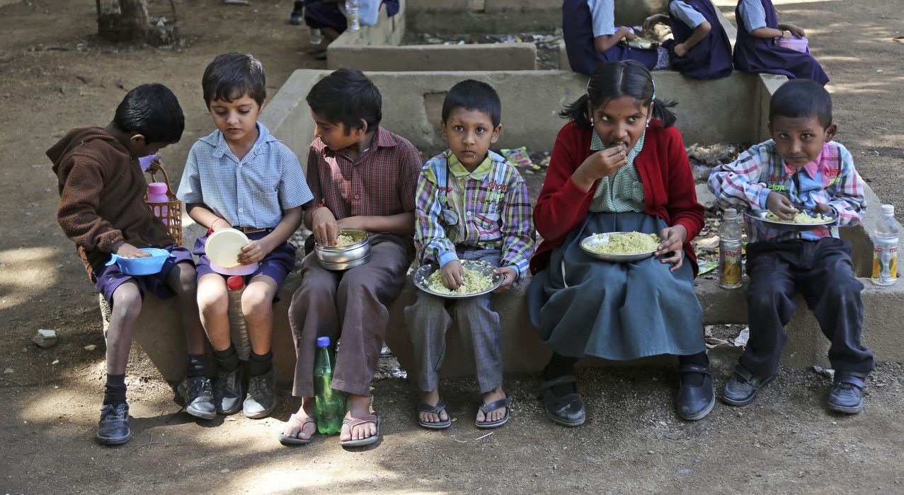 Indian school children sit outdoors and eat lunch at a government school in Hyderabad, India, Tuesday, Oct. 28, 2014. Indian women still face some of the world's worst inequality in access to health care, education and work, despite years of rapid economic growth, according to the annual Gender Gap Index by the Geneva-based World Economic Forum released Tuesday. India ranked an impressive 15th for female political participation, but it was among the bottom 20 in terms of income, literacy, work force participation and infant survival. (Mahesh Kumar A.) Ett hinder för kvinnor är brist på utbildning, något som resulterat i att bara 64 procent av landets kvinnor är skriv- och läskunniga, en siffra som ligger på 82 procent för männen