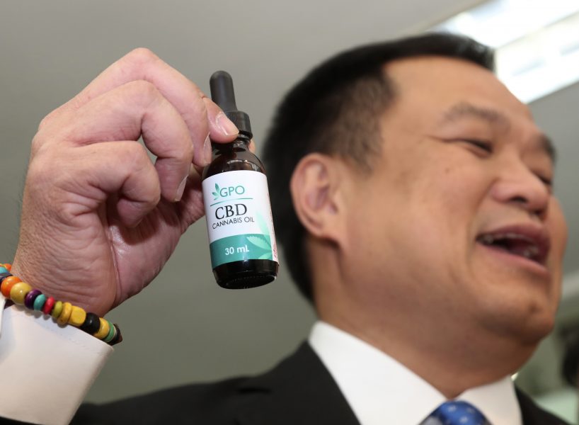 Thailands vice premiärminister Anutin Charnvirakul håller upp en femmillilitersflaska cannabisolja.
