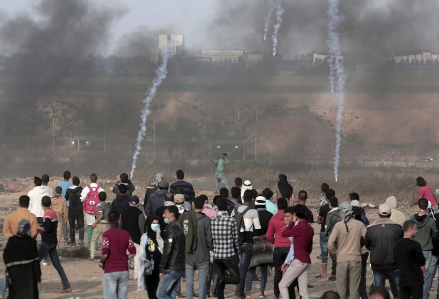 Demonstranter kastar stenar mot israeliska soldater under demonstrationerna på Gazaremsan våren 2018.