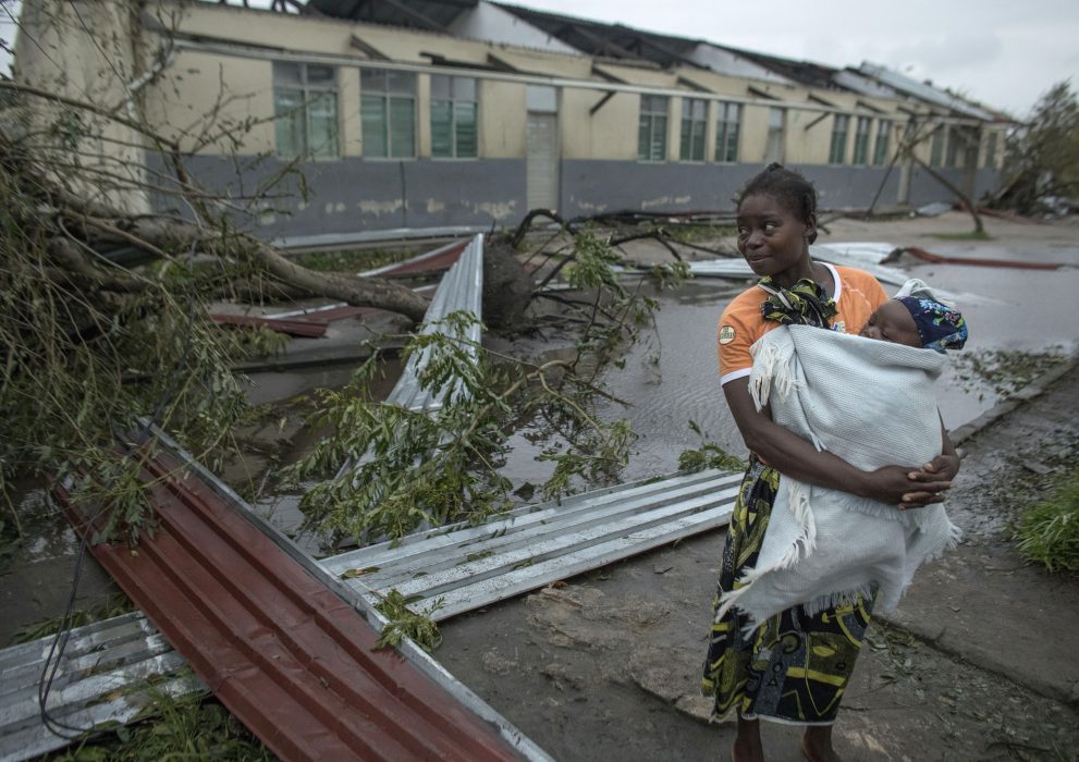 A woman makes her way to a school building being used as an emergency shelter for some 300 local people who are unable to return to their homes following cyclone force winds and heavy rain in the coastal city of Beira, Mozambique, Sunday March 17, 2019. More than 1,000 people are feared dead in Mozambique four days after a cyclone slammed into the southern African country destroying vulnerable residential areas. (Josh Estey/CARE via AP) Människor i Beira tar skydd i skolor med avblåst tak