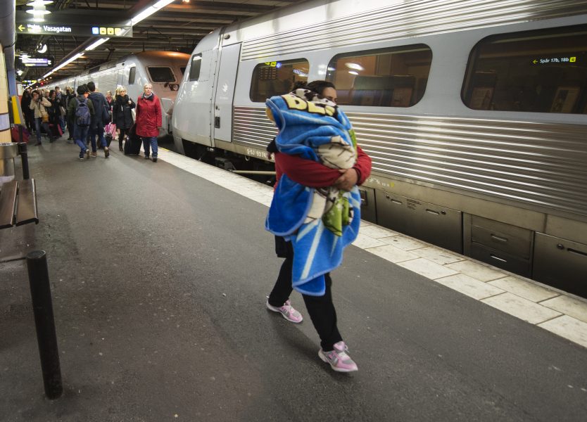 En kvinna med ett sovande barn anländer till Stockholm med tåget från Malmö/Köpenhamn under hösten 2015, då många flyktingar kom till Sverige.