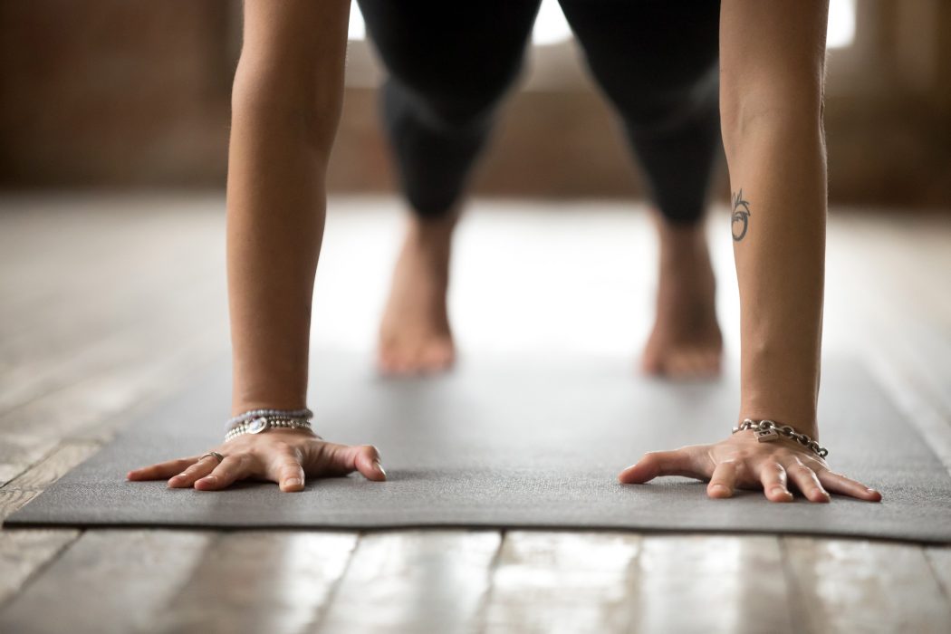 Young sporty woman practicing yoga, doing Push ups or press ups exercise, phalankasana, Plank pose, working out, wearing sportswear, black pants, indoor close up, yoga studio; Shutterstock ID 1033858468; PO: 123**BILDEN F≈R ENDAST PUBLICERAS TILLSAMMANS MED TT:S URSPRUNGLIGA TEXT OCH F≈R INTE ≈TERANVƒNDAS I ANDRA SAMMANHANG** Yoga är en kombination av fysiskt aktivitet och själslig behandling