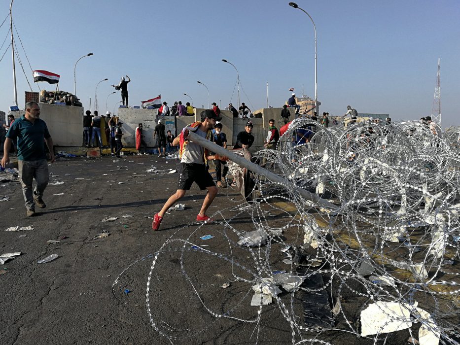 Iraqi anti-government protesters take control of concrete walls and barriers set by security forces that closes the Al-Sanak Bridge leading to the Green Zone, during a demonstration in Baghdad, Iraq, Thursday, Oct. 31, 2019. Late Wednesday, hundreds of people headed to the Al-Sanak Bridge that runs parallel to the Joumhouriya Bridge, opening a new front in their attempts to cross the Tigris River to the Green Zone. Security forces fired volleys of tear gas that billowed smoke and covered the night sky. (AP Photo/Hadi Mizban) BKM101 Regeringskritiska protester i Iraks huvudstad Bagdad den 31 oktober