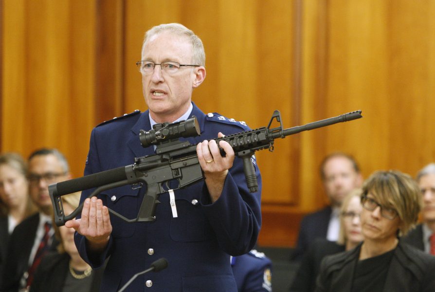Poliskommissarien Mike McIlraith visar upp ett vapen, av samma typ som användes av gärningsmannen vid moskéattackerna i Christchurch, i det nyzeeländska parlamentet i april.