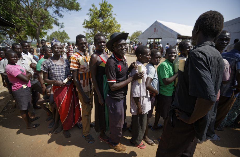 Sydsudanesiska flyktingar köar för att få en bit mark tilldelad vid ett läger i Uganda.
