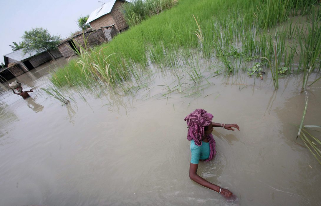 Villagers wade through flood water at Jafragonj, 40 kilometers (25miles) north of Dhaka, Bangladesh, Sunday, Sept. 7, 2008. Thousands of villagers have been displaced due to floods in northern Bangladesh. (AP Photo/Pavel Rahman) Många småbönder i Bangladesh drabbas av att havsvatten tränger in på åkrarna