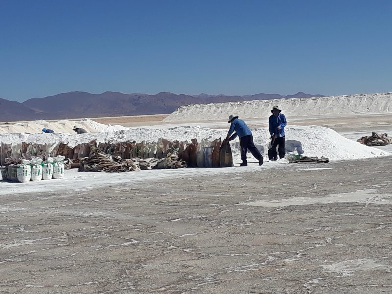 Två män arbetar med saltsäckar inom det kooperativ som drivs av ursprungsbefolkningen i Salinas Grandes.