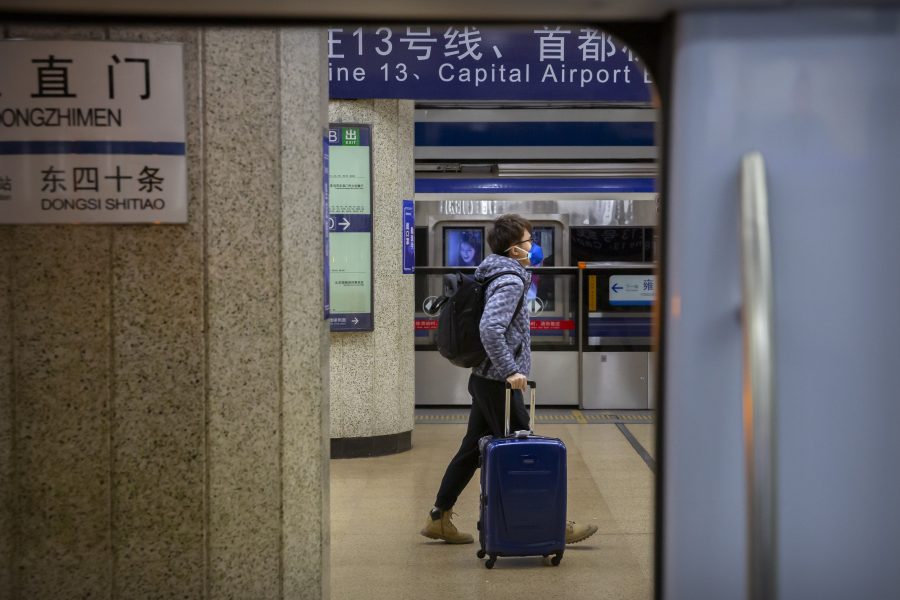 En man drar sin resväska i en tunnelbanestation i Peking.