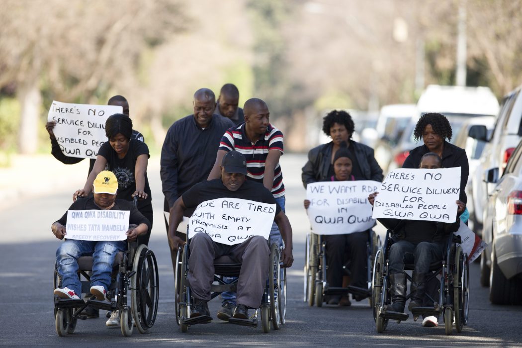 A group of disabled people from Qwa Qwa, in Free State province, carry placards calling for better services for the disabled and wishing a speedy recovery for former South African President Nelson Mandela, as they visit the residence where the former president continues to receive medical care, in Johannesburg, South Africa, Wednesday, Sept. 4, 2013. The group traveled five hours to Johannesburg to show their support for Mandela, who they called a champion for the disabled, and to call on the current government to address their needs. Current South African president Jacob Zuma said Tuesday that Mandela remains in critical condition, but notes the fact that he has left the hospital indicates the progress that he has made.(AP Photo/Rebecca Blackwell) Personer med funktionsvariationer i Sydafrika kräver att deras rättigheter ska tillgodoses