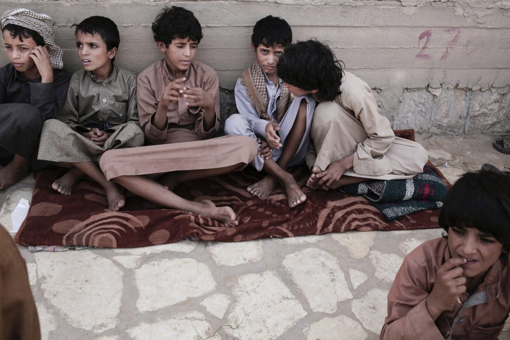 In this July 27, 2018, photo, 14 year-old Abdel Hamid, second right, and 14 year-old Morsal, third right, sit at a camp for displaced persons where they took shelter, in Marib, Yemen. Both boys were child solders forcibly enlisted by Houthi rebels and put to work carrying ammunition and supplies to the front lines. Abdel-Hamid says he saw children get shot for disobeying orders. Morsal suffered partial hearing loss from explosions and airstrikes. (AP Photo/Nariman El-Mofty) Barn som sökt skydd i ett flyktingläger i Marib, Jemen
