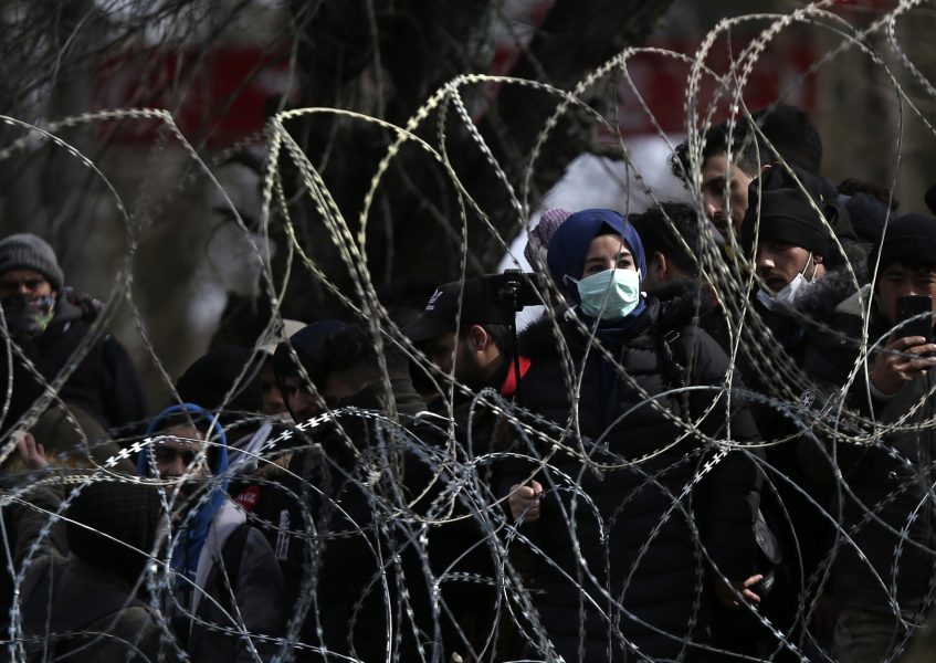 Migranter och flyktingar bakom ett taggtrådsstängsel vid gränsen mot Turkiet nära Kastanies i nordöstra Grekland.