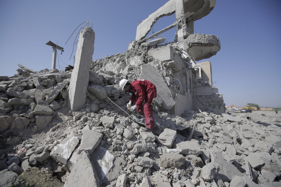 En räddningsarbetare letar överlevande i ruinerna efter en saudisk-ledd flygbombning.