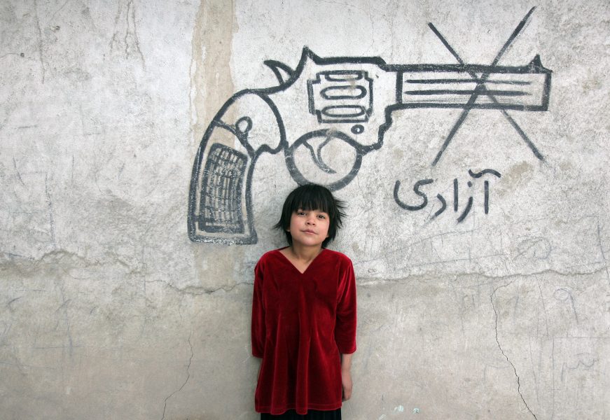 Ett barn syns bredvid en väggmålning med ordet "frihet", i Afghanistans huvudstad Kabul.