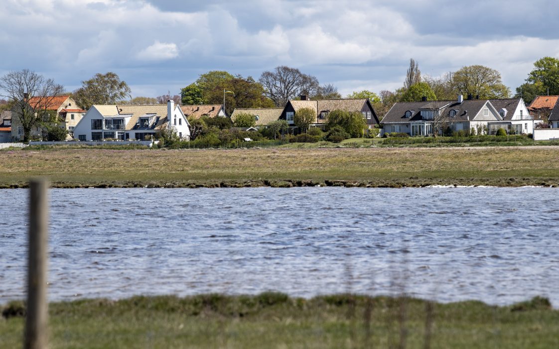 SKANÖR 2020-05-05
Vyn som kommer att förändras om muren byggs vid fastigheterna norr om Hamnvägen i Skanör. Falsterbonäset i Skåne med vitskimrande stränder och praktfulla strandvillor ligger riskabelt till när havsnivån stiger. Kommunen vill satsa mångmiljonbelopp på skyddsvallar och murar till priset av förstörd utsikt för vissa.
Foto: Johan Nilsson / TT / Kod 50090 Strandvillorna i Falsterbonäset i Skåne ligger riskabelt till när havsnivån stiger