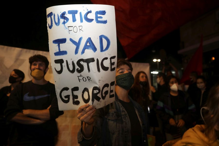Demonstranter i Jerusalems gamla stadskärna håller upp plakat som kräver rättvisa för Iyad Halak och George Floyd.