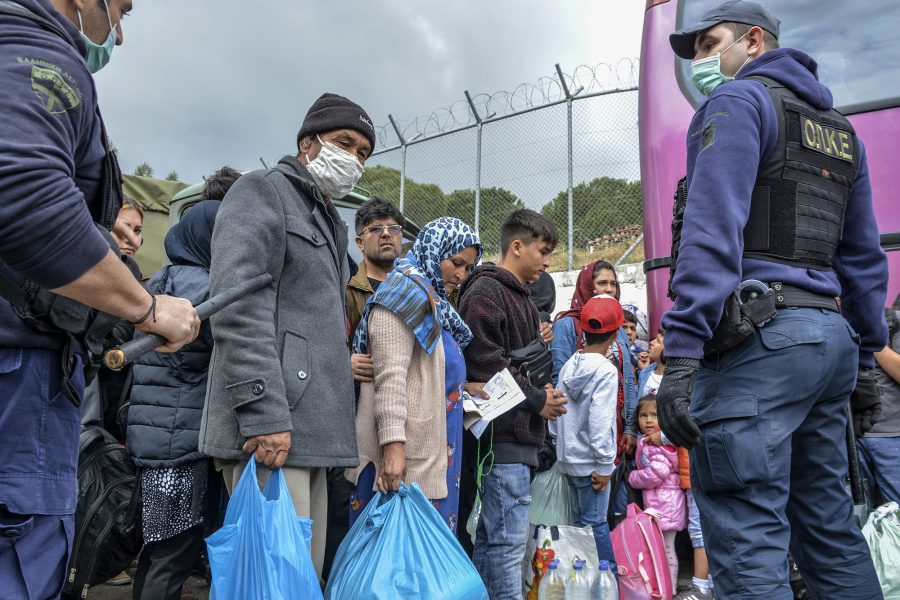 Migranter står uppställda utanför Morialägret på Lesbos.