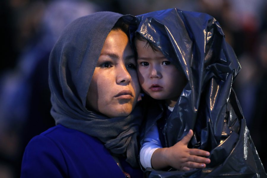 En afghansk kvinna anländer till fastlandet med sitt barn från Lesbos där myndigheterna försöker minska belastningen på de överfulla flyktinglägren.