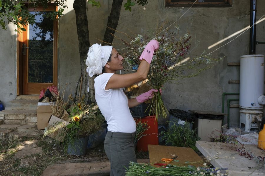 Yasmina Zaher binder blommor odlade på marken som hon tagit över tillsammans med sin man och partner.