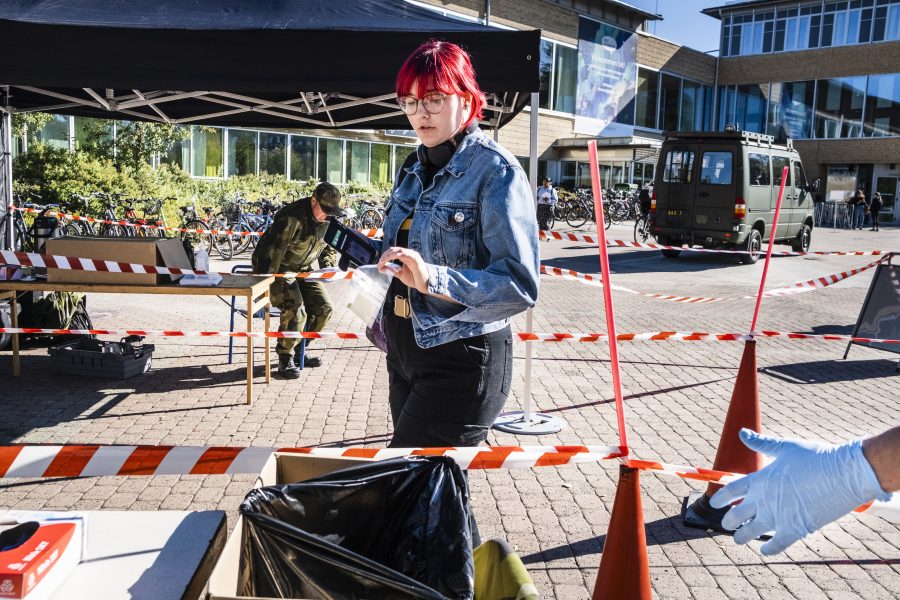 Militär bistår med personal vid Umeå Universitet när studenten Tove Viklund lämnar sitt covid-19-test.