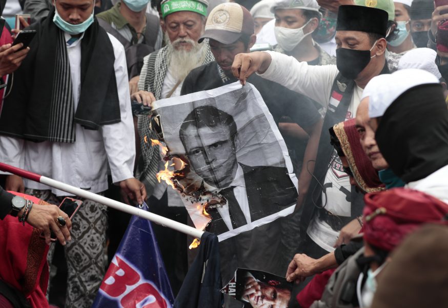 Ett porträtt av president Emmanuel Macron bränns under en antifransk demonstration i Jakarta i Indonesien på måndagen.