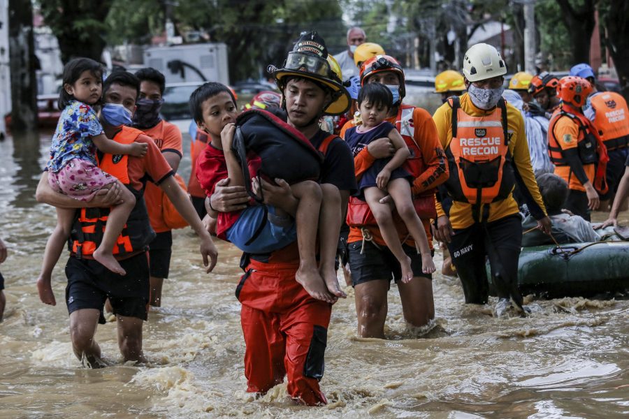 Räddningsarbetare bär bort barn från en översvämmad gata i staden Marikina, öster om Filippinernas huvudstad Manila efter tyfonen Vamcos framfart över Filippinerna nyligen.