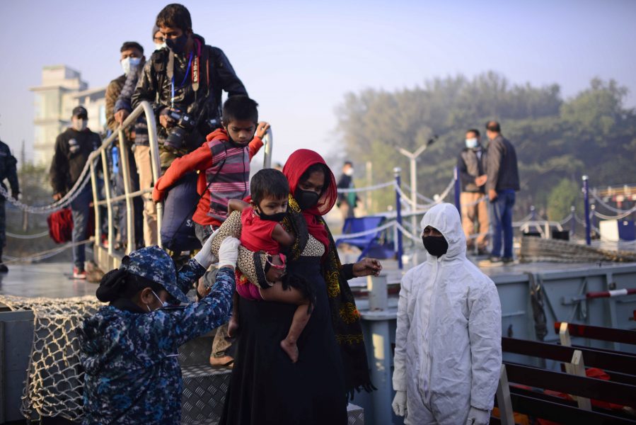 Rohingyaflyktingar går ombord på ett fartyg till ön Bhashan Char i Bangladesh under tisdagen.
