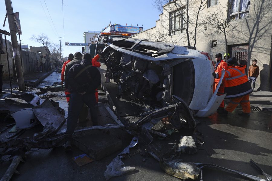 Säkerhetsstyrkor och kommunalarbetare flyttar en demolerad bil efter tisdagens bombdåd i Kabul.