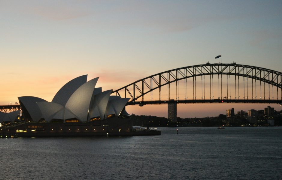 Operahuset i Sydney i skymning framför Harbour Bridge.