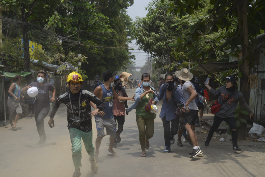 Demonstranter flyr militären efter en demonstration i Rangoon i tisdags.