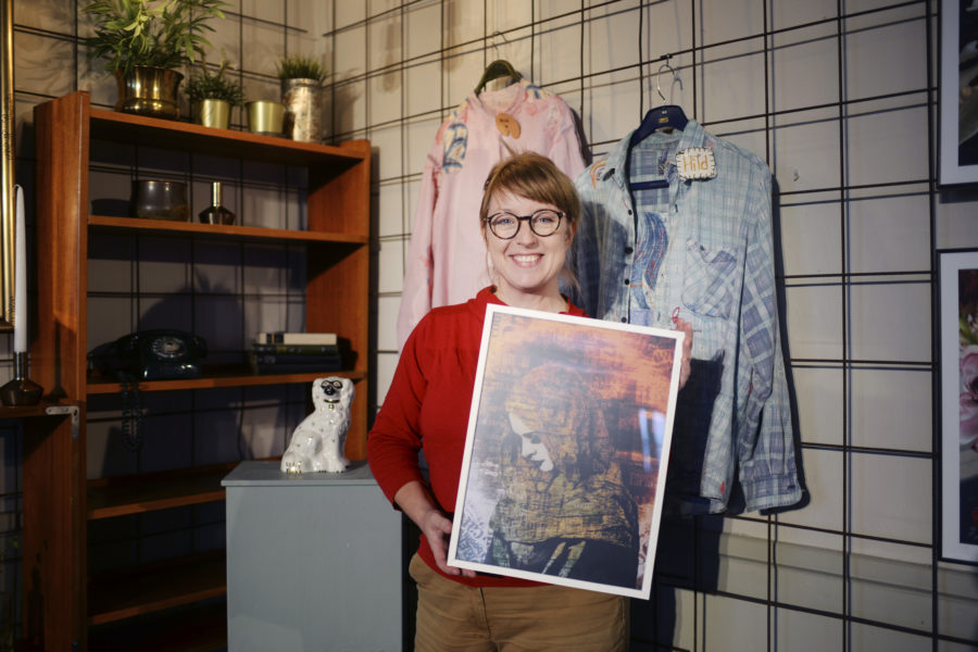 Linda Engström, konstnär och projektledare för KlimatSalongen håller i en tavla skapad av Jonatan Blixt.