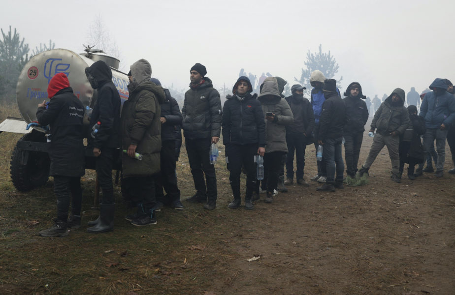 Migranter köar för att få dricksvatten vid gränsen mellan Belarus och EU-landet Polen.