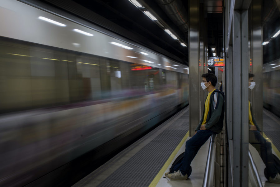 En ung man i Barcelona väntar på tåget.