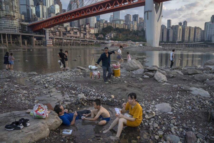 Boende i staden Chongqing försöker svalka sig i pölar som bildats i Jialingfloden, en biflod till Yangtze, när vattennivån sjunkit undan.