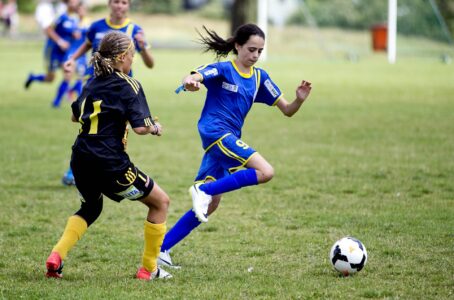 Två tjejer på en fobollsplan.