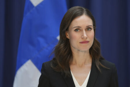 Finlands statsminister Sanna Marin framför den finska flaggan.