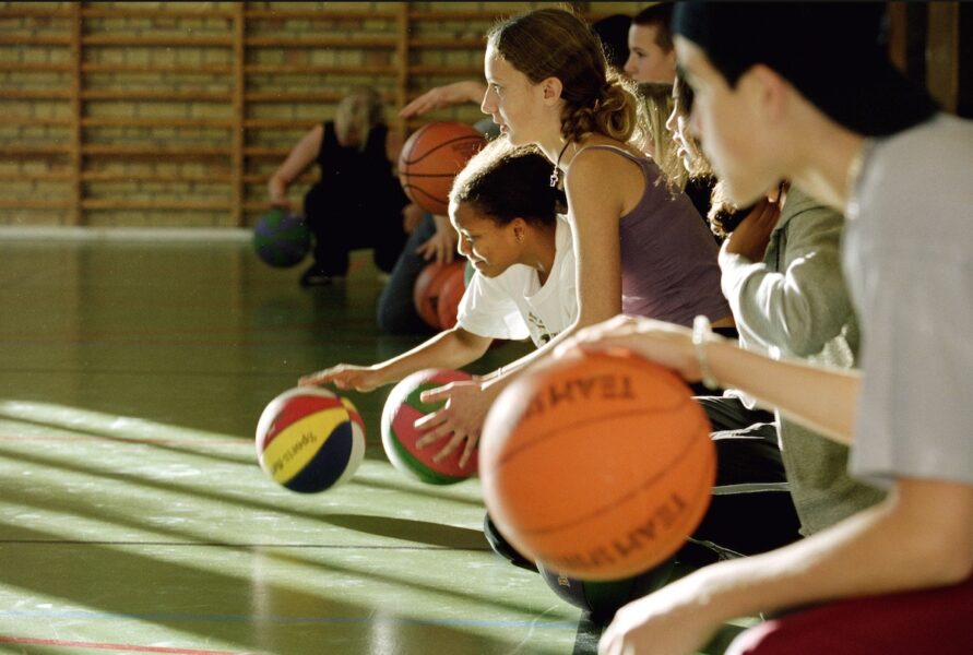 Ungdomar spelar basket.