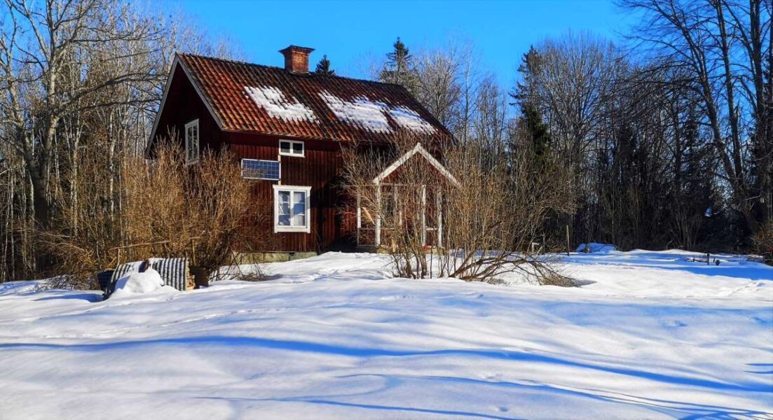 Ett hus i ett vintrigt landskap.