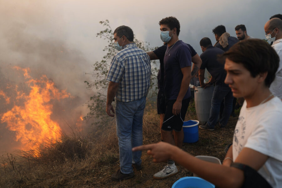 Lokalbor försöker begränsa en skogsbrand som närmar sig deras bostäder i Alcabideche utanför Lissabon, 25 juli 2023.