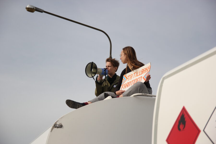 Två aktivister har klättrat upp på en tankbil under en aktion i Södertälje 25 september.