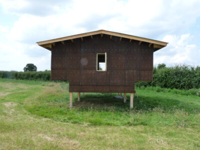 En brun byggnad upphöjd på ben, byggd av hampabaserat material.