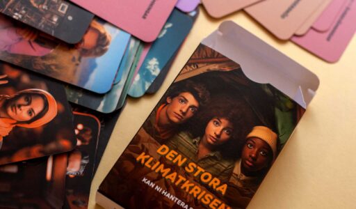 Spelkort lite rörigt utlagda och en ask med titeln Den stora klimatkrisen. På asken syns ansikten från tre rädda ungdomar.