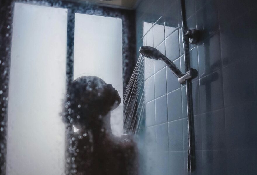 Silhuett av en duschande person i grå färgskala.