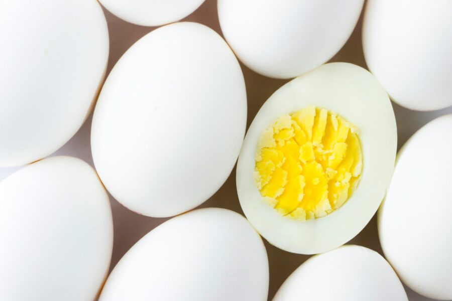 Ägg i närbild varav ett är uppskuret så hårdkokt gula syns.