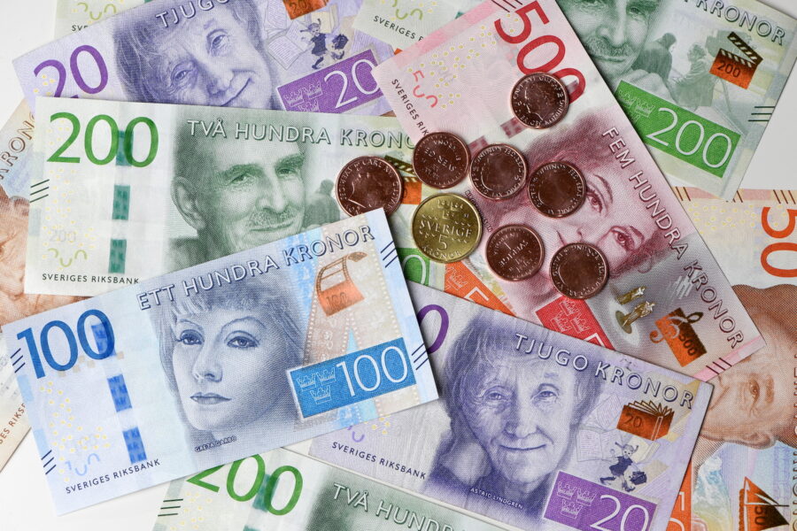 Svenska sedlar och mynt utspridda på en plan yta.