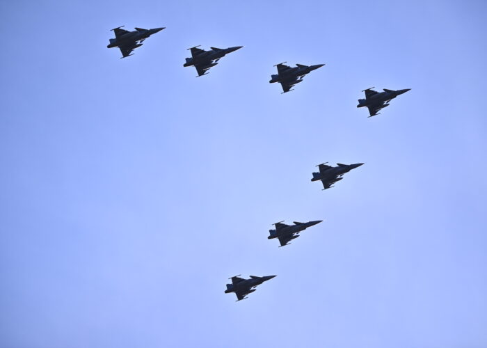 Sju flygande Jas-plan bildar ett V mot blå himmel.