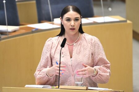 Ung kvinna talar i riksdagen. Yasmine Bladelius