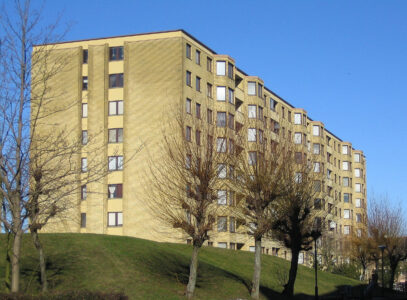 Ett större flerfamiljshus på en höjd.