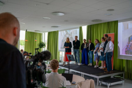 Person bakifrån filmar sju deltagare i medborgarråd om klimatet.