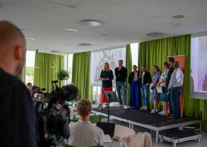 Person bakifrån filmar sju deltagare i medborgarråd om klimatet.